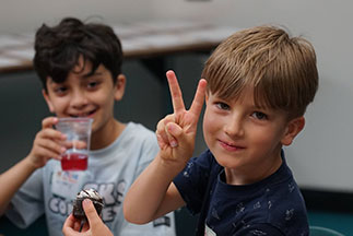A boy holding up a peace sign. Links to Gifts That Protect Your Assets