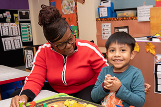 A woman helping a boy. Links to Gifts That Pay You Income